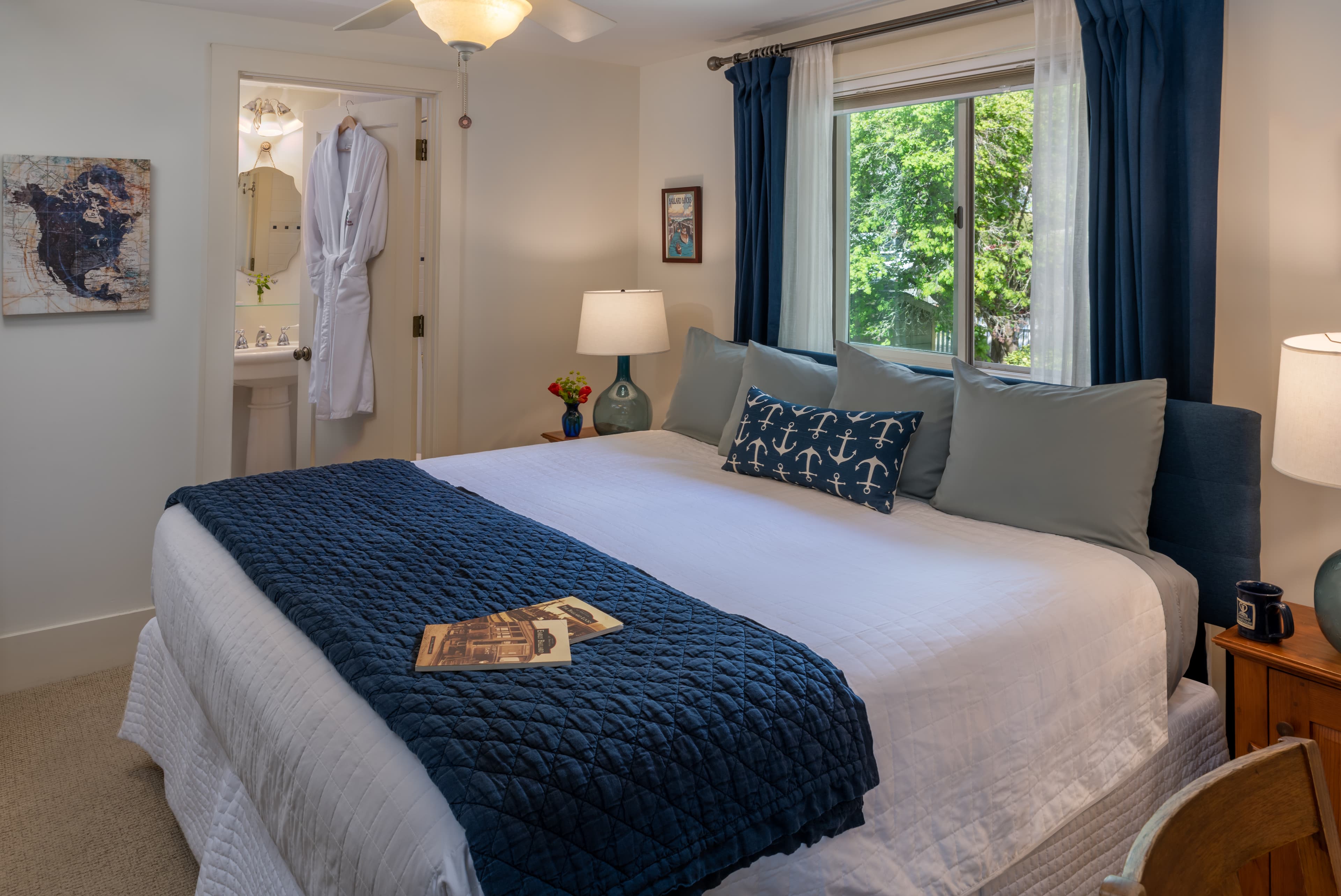 Cozy bedroom with a neatly made bed, blue accents, and an adjoining bathroom.