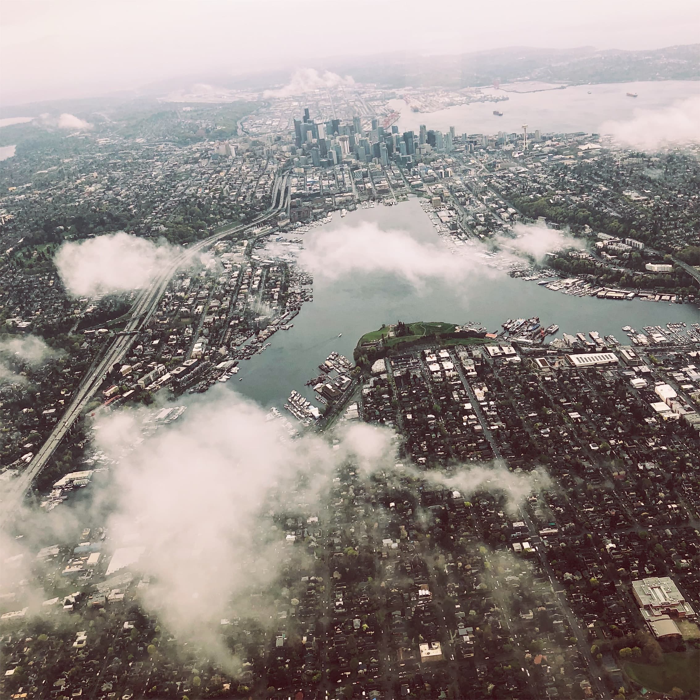 Aerial view of a city with a waterfront and cloudy sky. Aerial view of a city with a waterfront and cloudy sky.