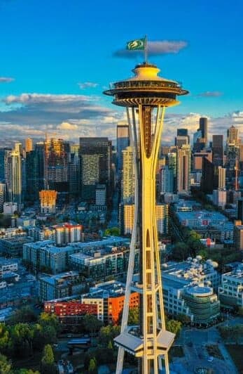 Aerial view of the Seattle Space Needle surrounded by city buildings and a clear blue sky.
