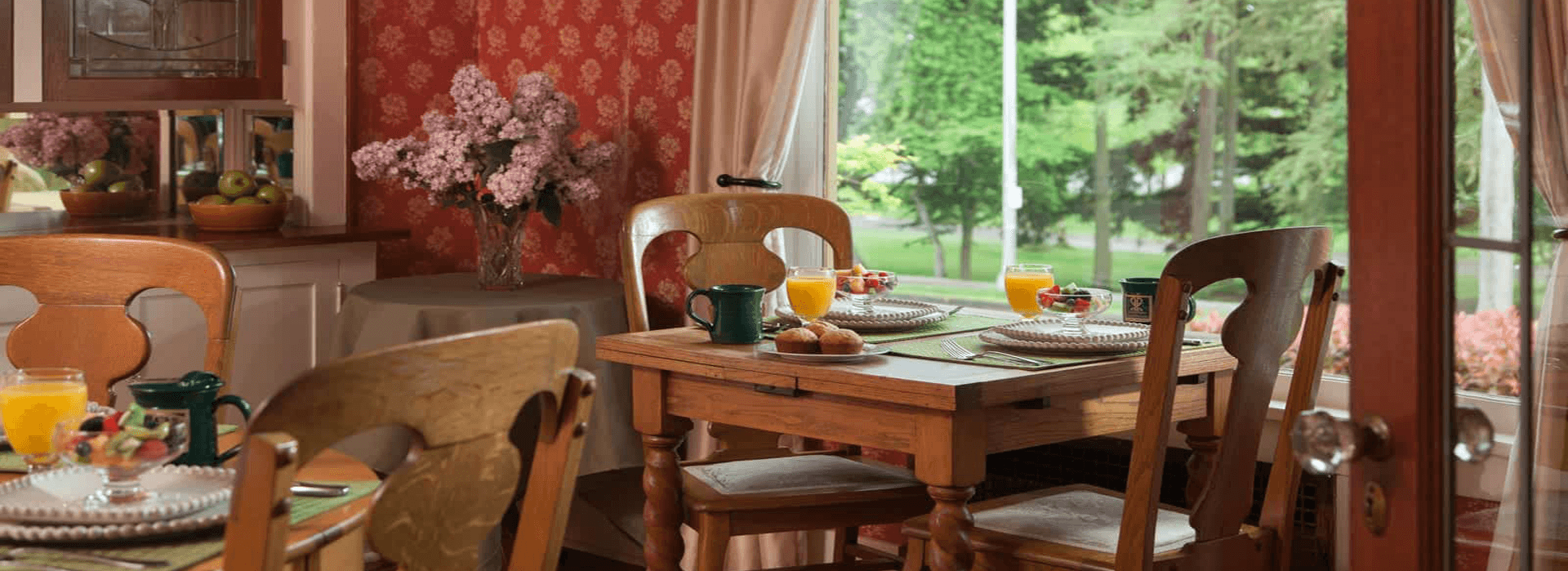 Cozy breakfast setting with fruit, drinks, and floral decor.