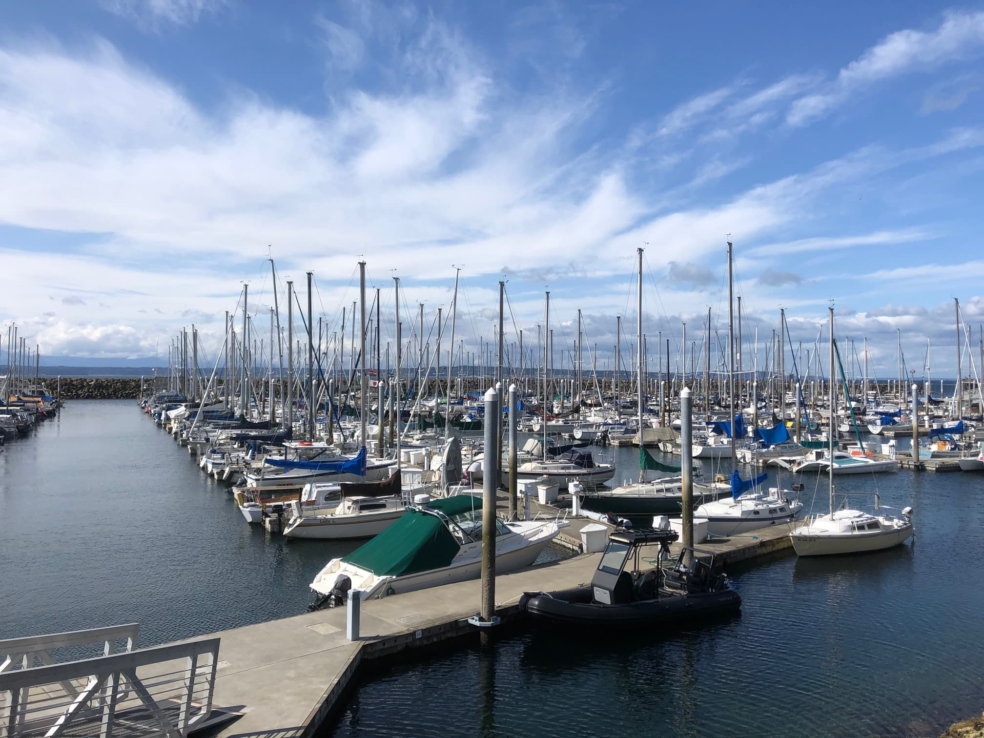 A scenic marina filled with various sailboats and yachts under a partly cloudy sky. A scenic marina filled with various sailboats and yachts under a partly cloudy sky.