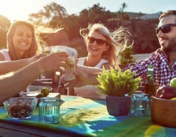 A group of friends toasting together at a vibrant outdoor table.