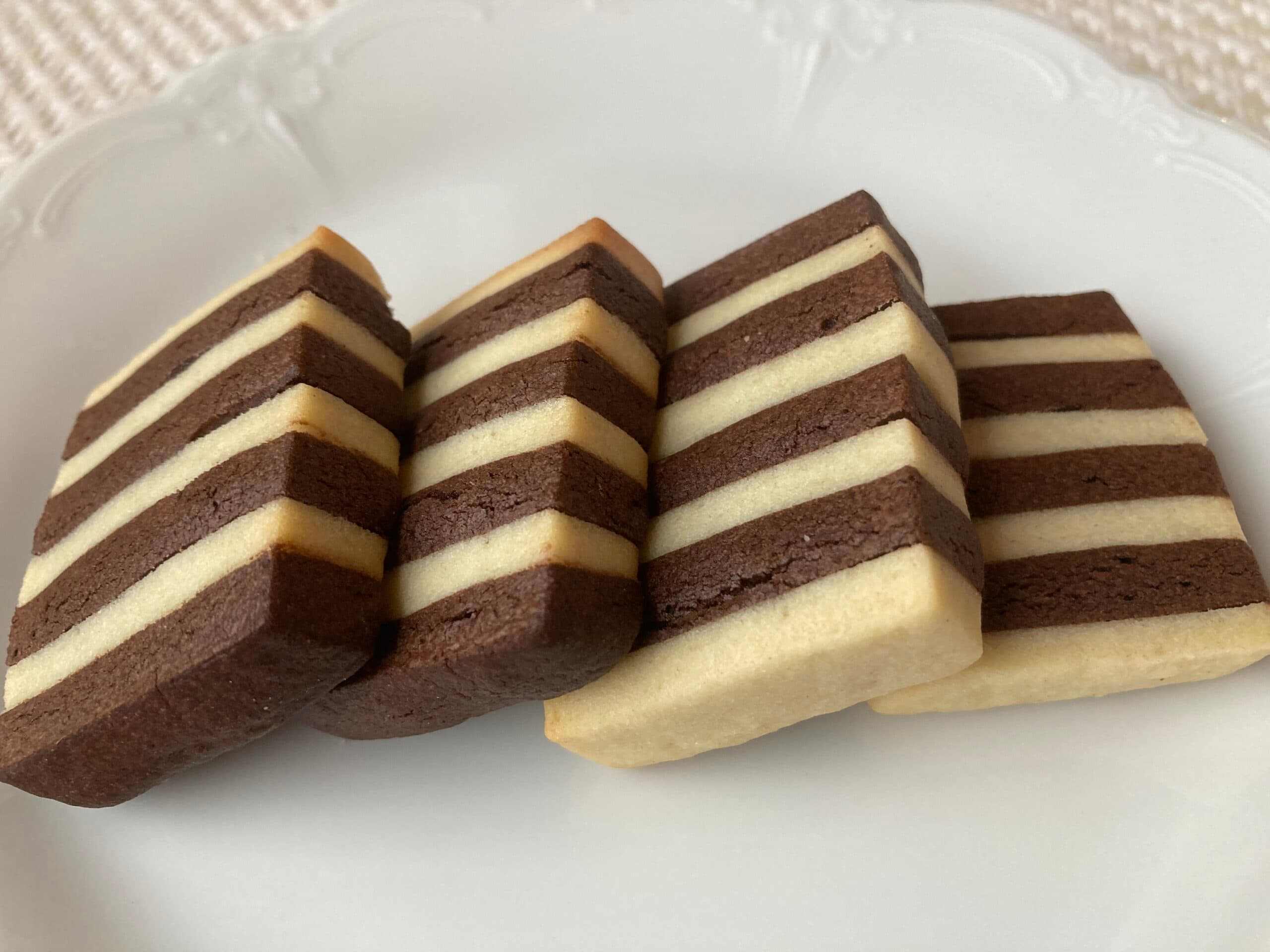 A plate of chocolate and vanilla striped cookies stacked neatly.