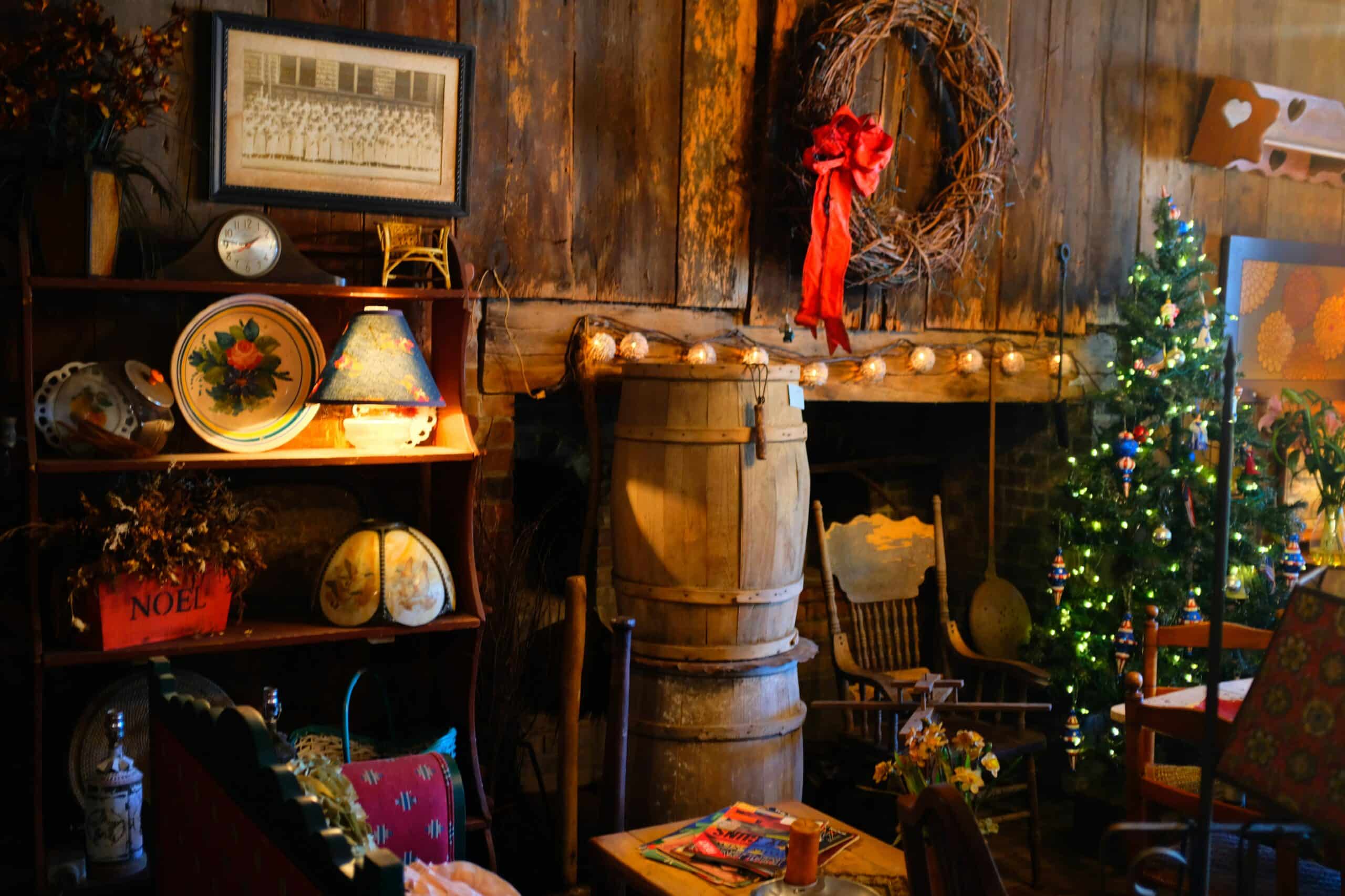 A cozy rustic room decorated with a Christmas tree, festive lights, and vintage decor.