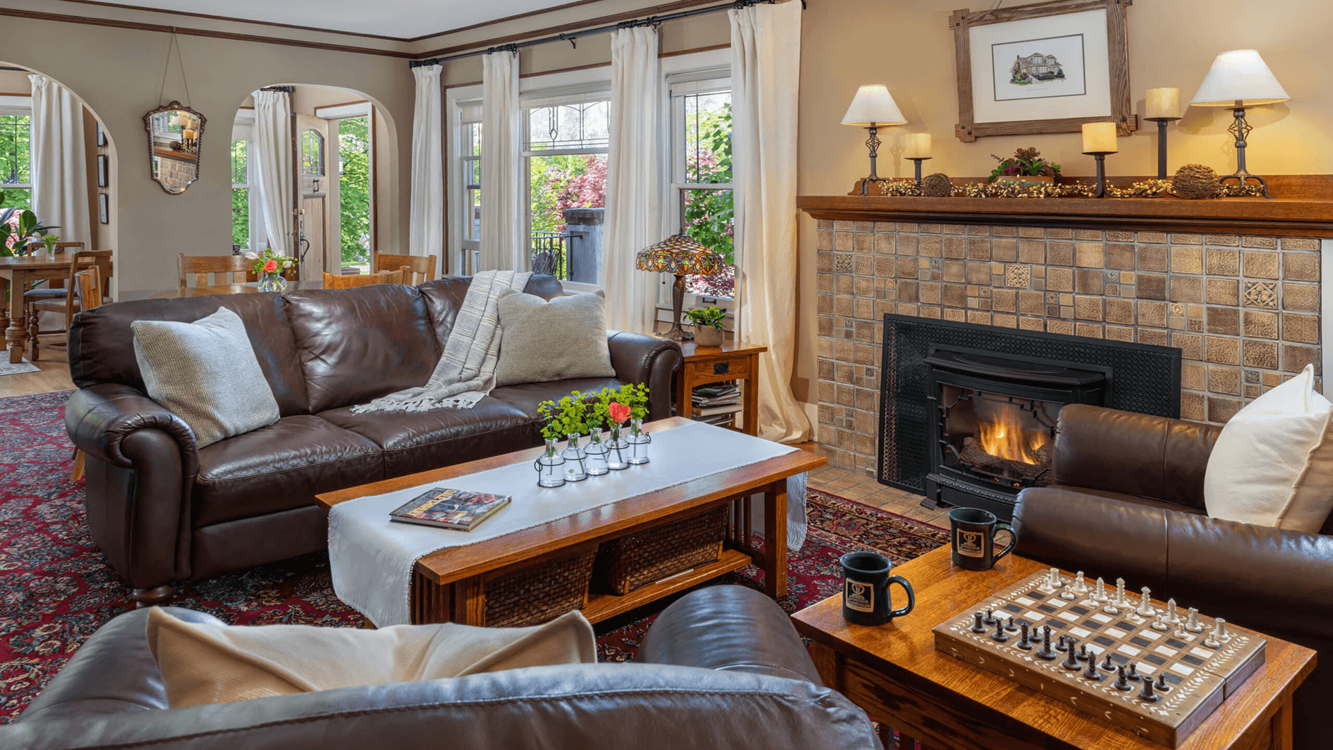 Cozy living room featuring leather sofas, a fireplace, and a chessboard.