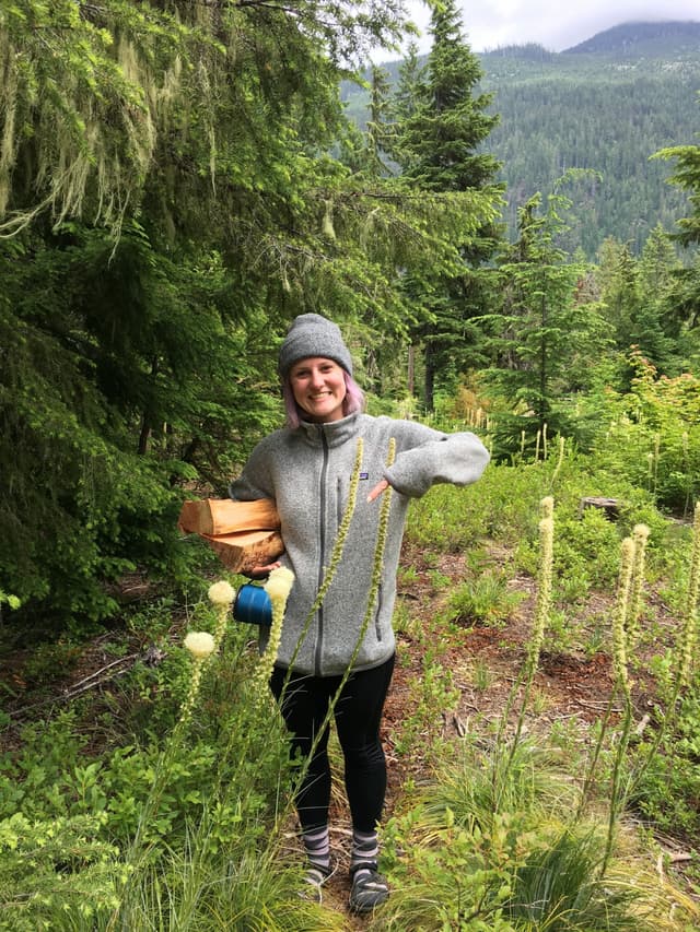 girl holding firewood in the woods