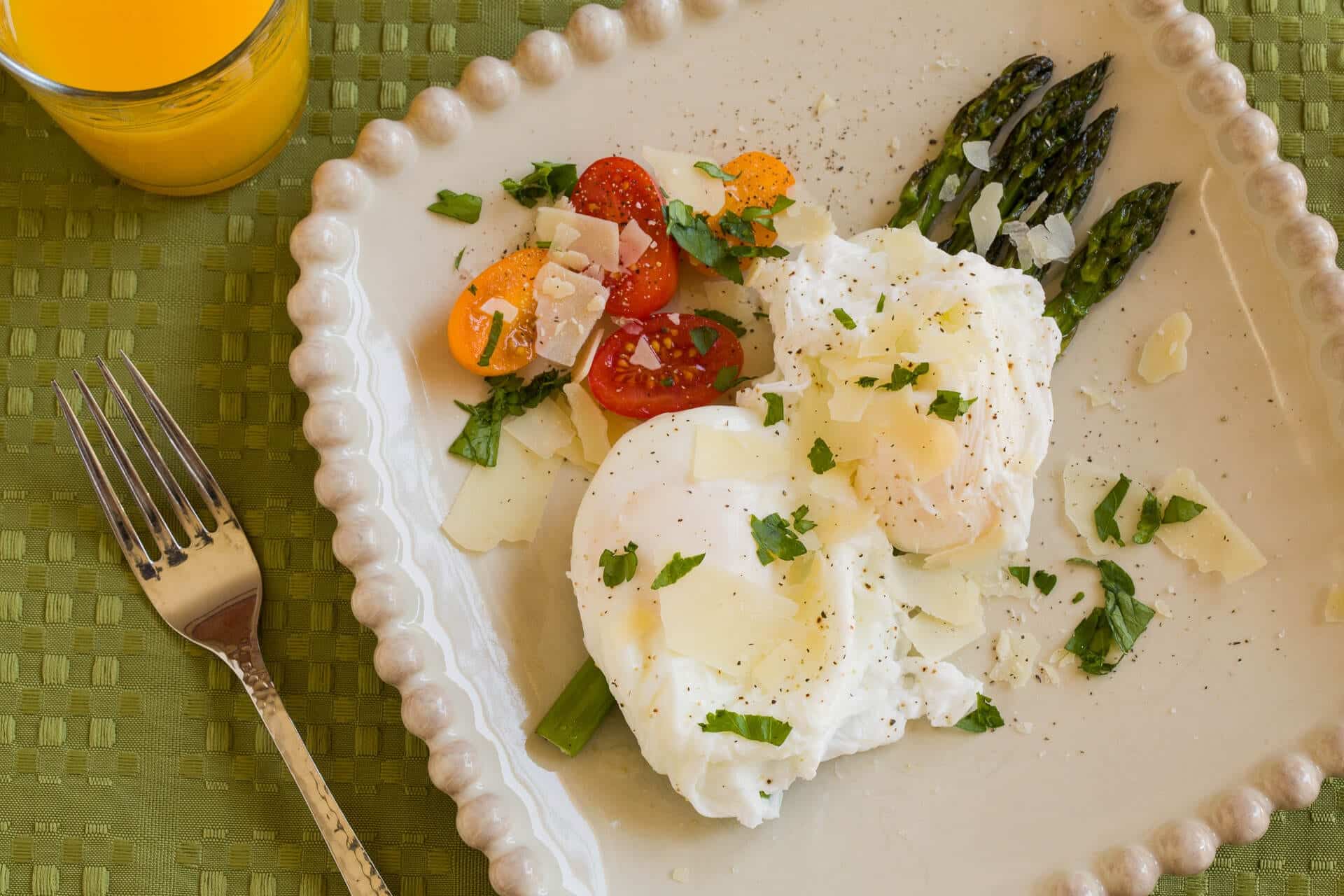 Poached eggs with vegetables and a glass of orange juice