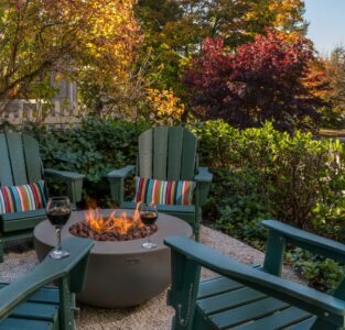 firepit with chairs and trees with fall color