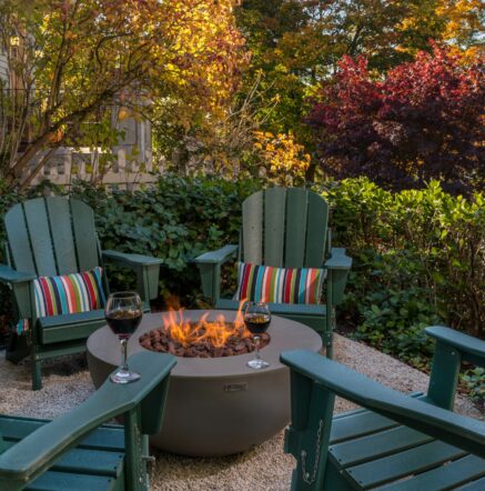firepit with chairs and trees with fall color